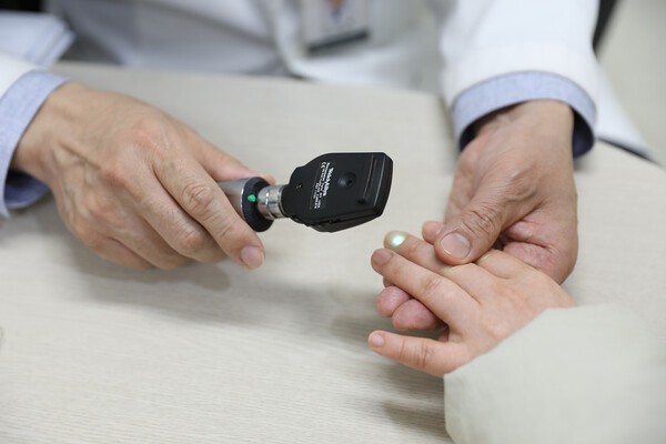 일산백병원 소아청소년과 김영대 교수가 진료 중 아이 손끝을 살펴보고 있다.